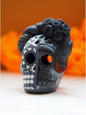 Black decorative skull with bright multicolored floral beadwork and sculpted rose headdress.