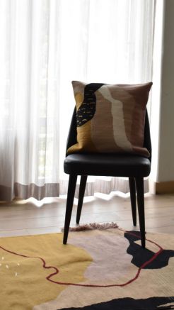 Abstract woven pillow cover with beige, black, cream, and mustard geometric patterns