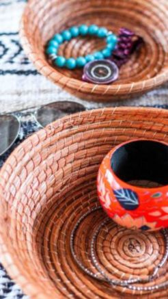 Handwoven pine needle baskets organizing a painted bangle, beaded bracelet, watch, necklace, and sunglasses.