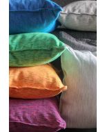 Stack of colorful textured pillow covers in blue, green, orange, pink, white, and grey shades showing fabric details.