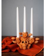 Colorful Día de Muertos altar with marigold garlands, skeleton figures, decorated skulls, candles, food, and portraits.